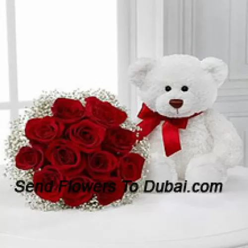 Um buquê de 12 rosas vermelhas com preenchedores sazonais junto com um fofo urso de pelúcia branco de 14 polegadas de altura