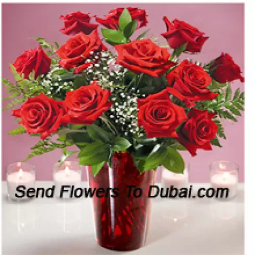 12 Trandafiri roșii cu câteva frunze de ferigă într-o vază de sticlă