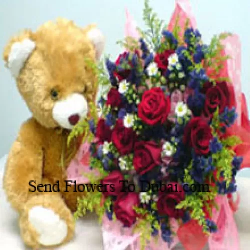 Um buquê de 12 rosas vermelhas com complementos e um urso de pelúcia de tamanho médio e fofo